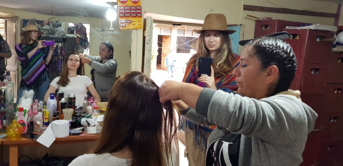 Марине плетут косы в местной рeluqería